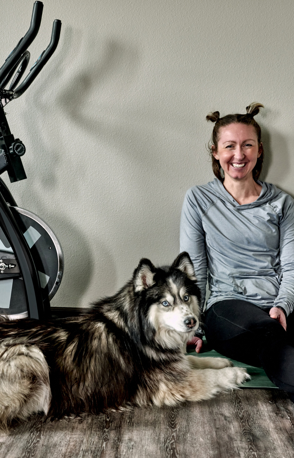 A woman sitting down with her husky.